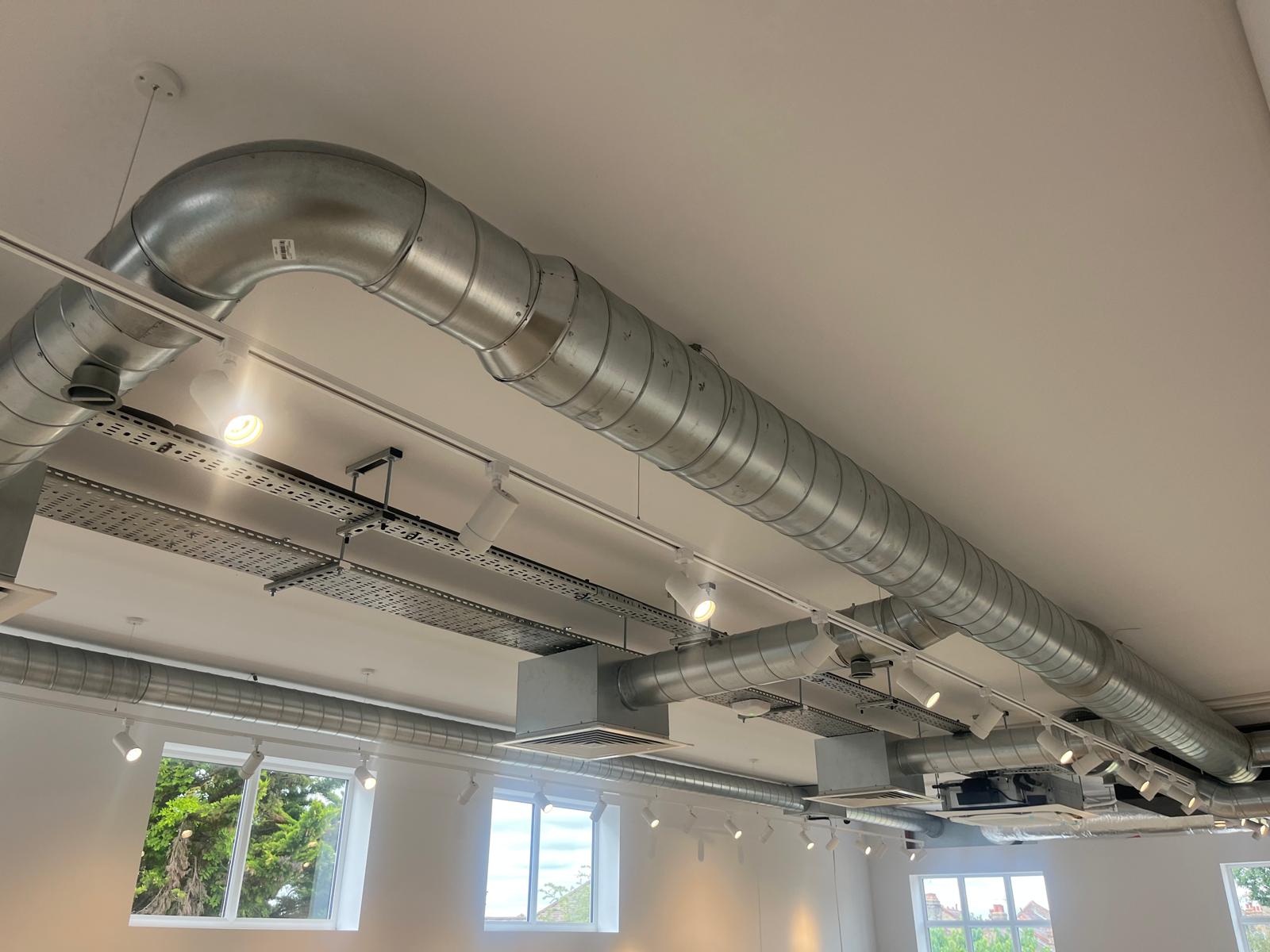 Exposed ceiling ductwork cleaned of construction dust